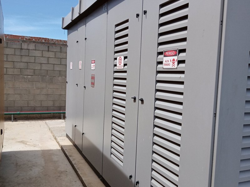 Subestação abrigada em cabines metálicas, com sinalização de alta tensão