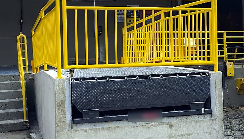 Doca com guarda-corpo metálico e base de concreto executados em área logística