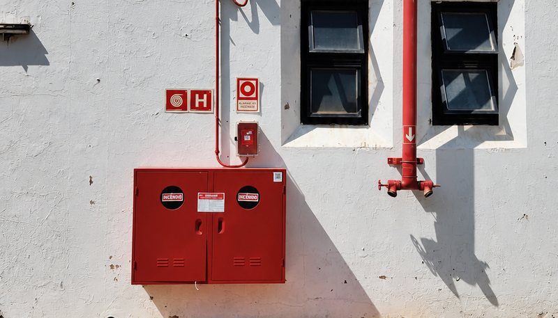 Abrigo de hidrante, acionador de alarme e sinalização instalados em fachada industrial